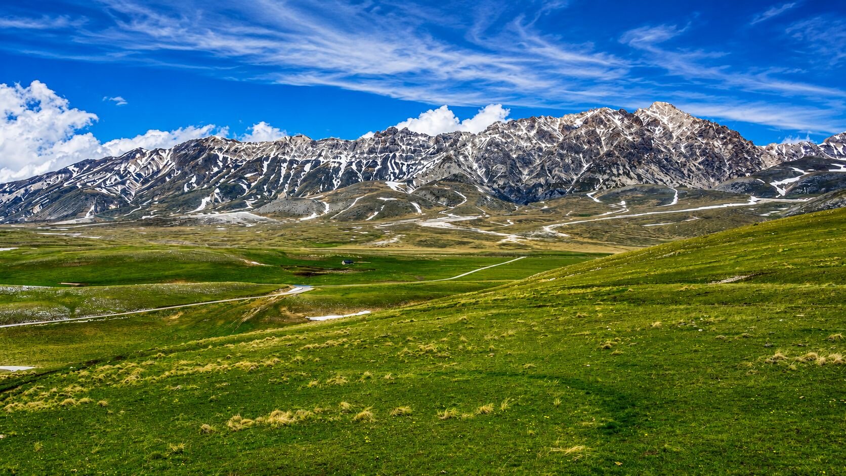 Veduta panoramica di Campo Imperatore, tra praterie d’alta quota e montagne del Gran Sasso in Abruzzo | © Generata con IA